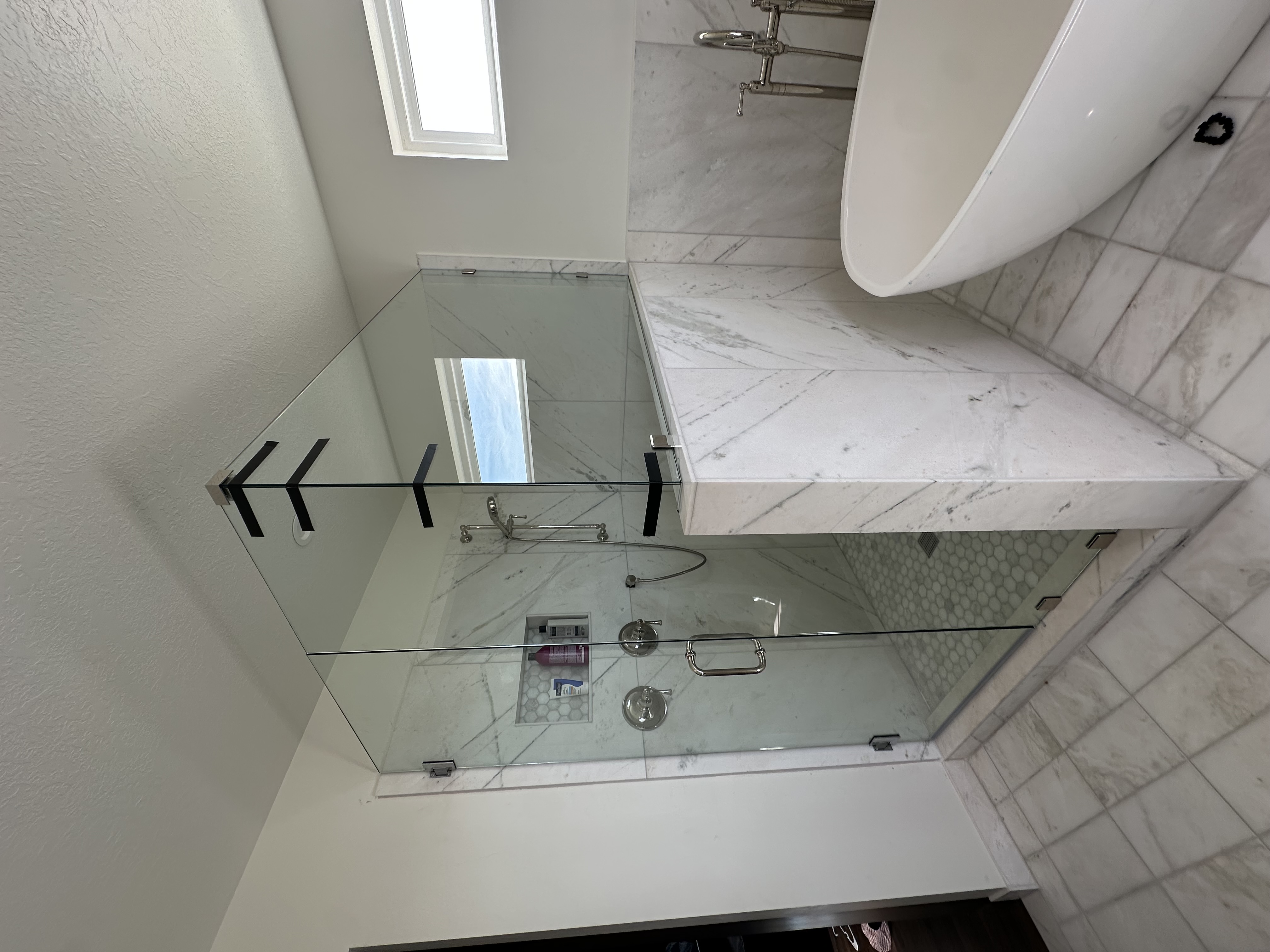 Custom frameless glass shower enclosure installed by Seidon Glass